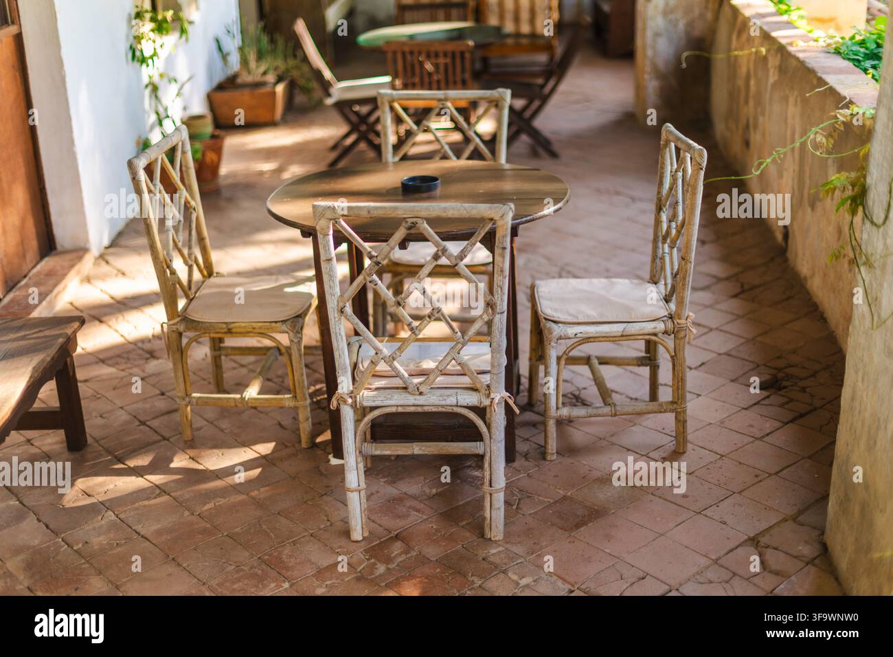 Rustikale mediterrane Terrasse mit Holztable und traditionellen Stühlen Stockfoto
