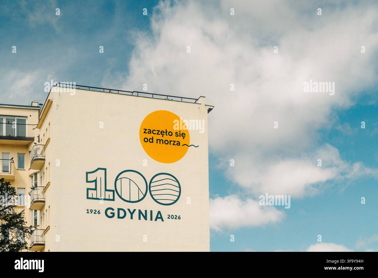 Ein großes Wandgemälde an der Seite eines Wohnhauses in Gdynia, Polen, feiert das 100-jährige Jubiläum der Stadt (1926–2026) mit dem polnischen Slogan "zacz Stockfoto