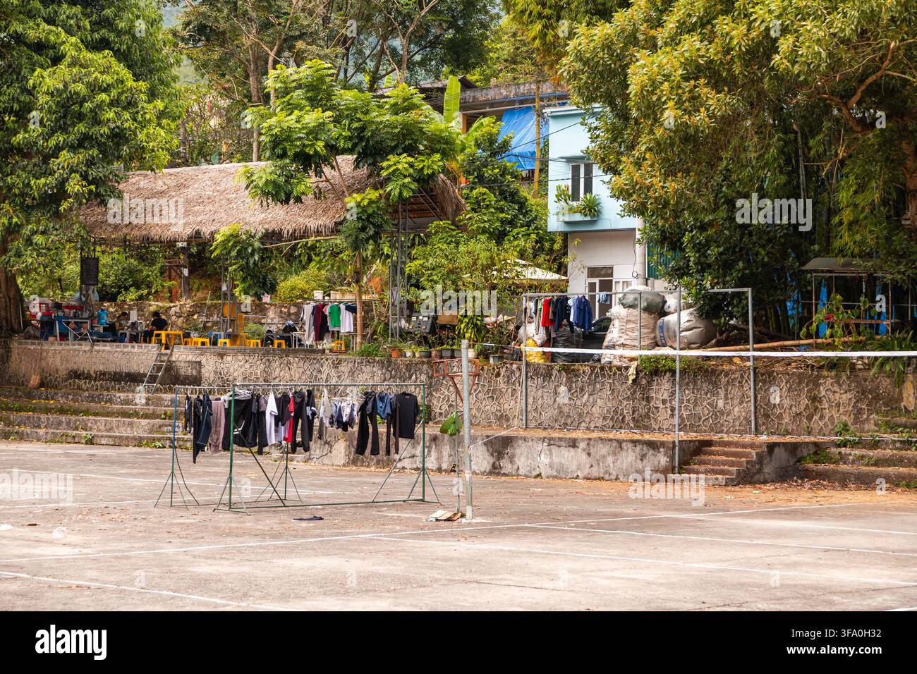 Thong Nguyen, Vietnam - 12. Oktober 2023: Wäsche, die auf Regalen vor einem strohgedeckten Gebäude und einem Wohnhaus trocknet Stockfoto