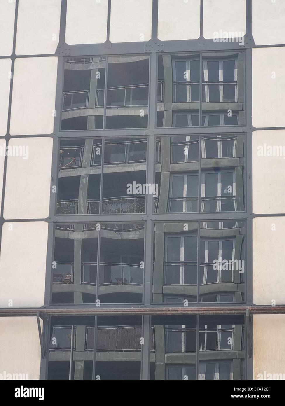 Abstrakte Reflexion von Wohnungsbalkonen auf industriellem Glasfensterraster in Oostenburg Amsterdam. Konzept der Unternehmensdurchsicht, Refl - Smartphone-aufgenommenes Stockfoto
