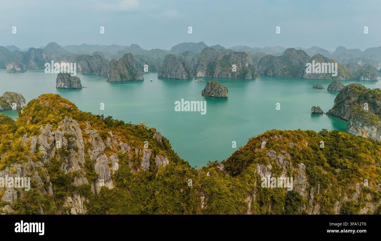 Scenische Luftpanorama von Kalkstein-Karstinseln, die aus dem türkisblauen Meer in der Lan Ha-Bucht, Hai Phong, Vietnam, aufragen, mit üppiger Vegetation, felsigen Klippen und Stockfoto