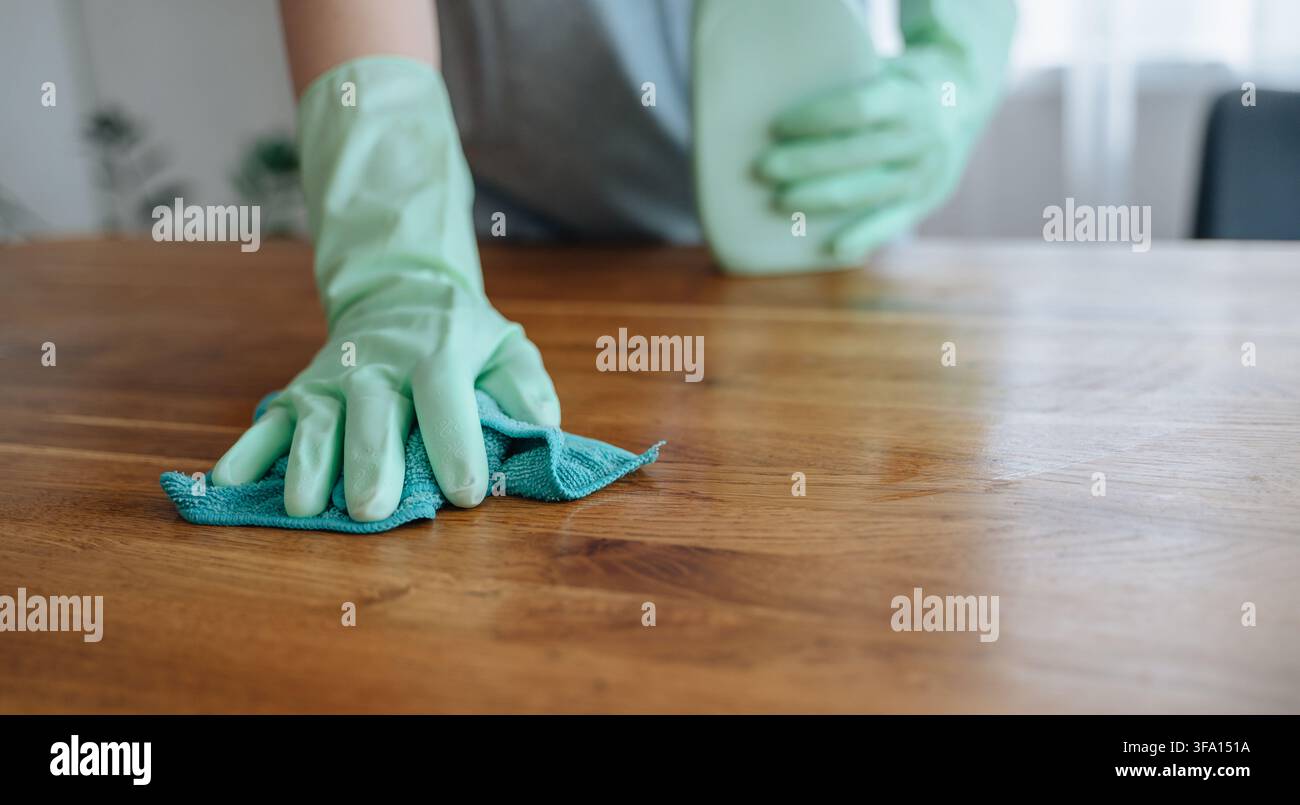 Frau wischt Esstisch mit einem Tuch ab, alltägliche Hausarbeit und ordentliches Zuhause Konzept. Hochwertiges Foto Stockfoto