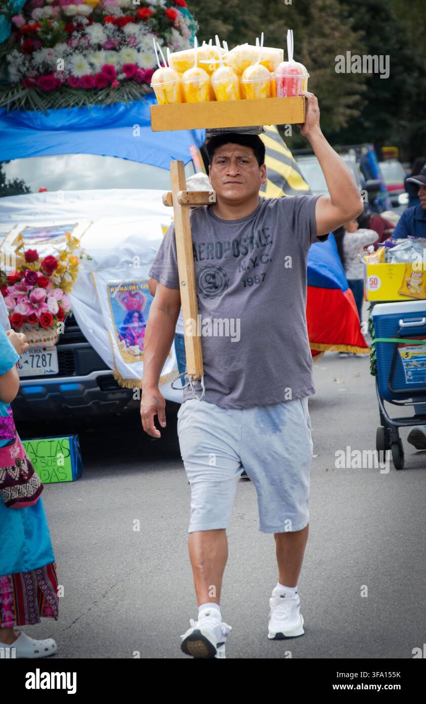 Ein Obstverkäufer geht zu seinem Stand, bevor die Ecuadorianische Tagesparade 2026 beginnt. In der 69th Street in Jackson Heights, Queens, NY. Stockfoto