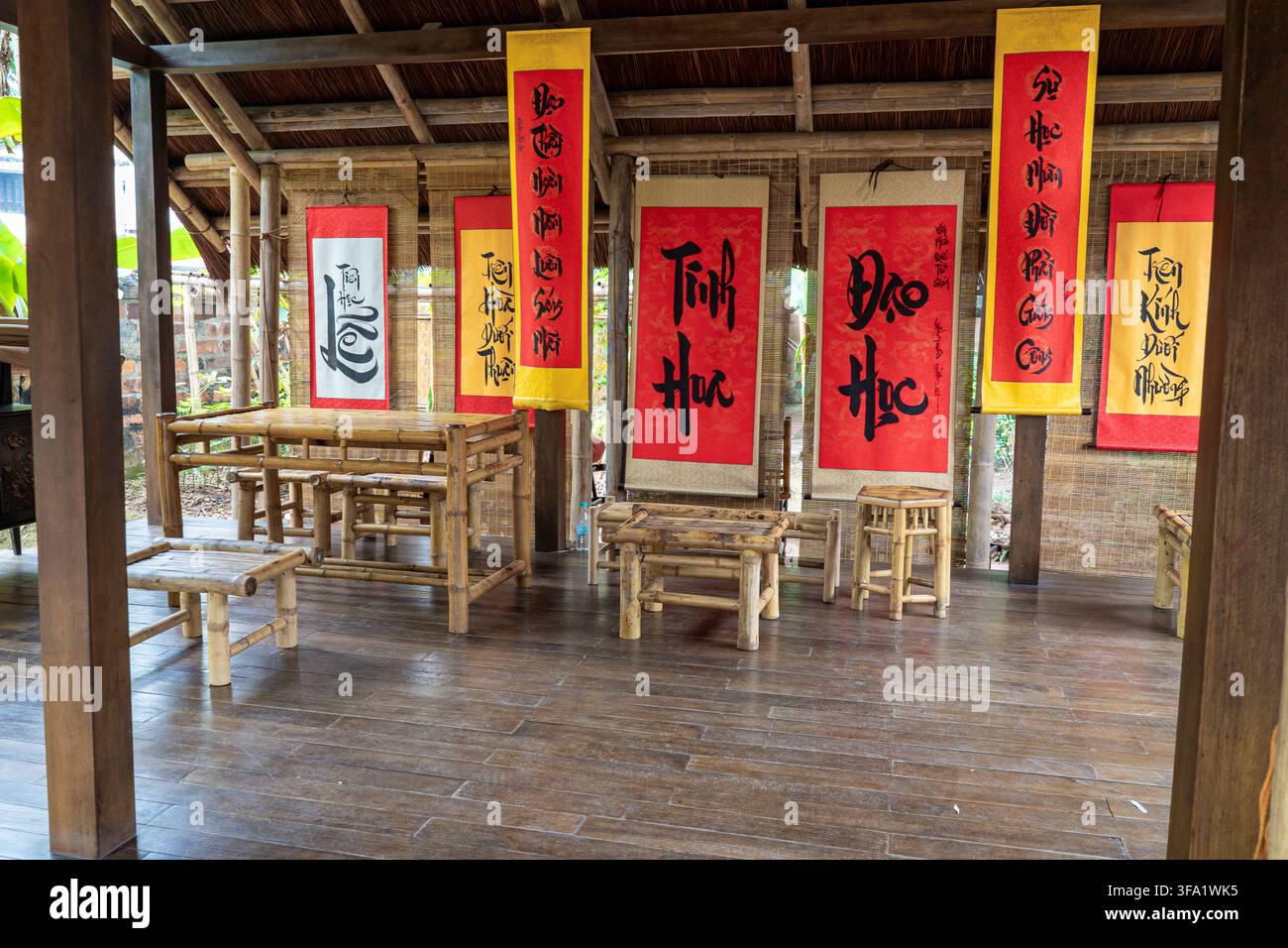 Ein traditionelles vietnamesisches Ambiente mit Bambusmöbeln, Kalligrafie-Rollen, mit kulturellen Elementen und Ästhetik aus Vietnam. Stockfoto