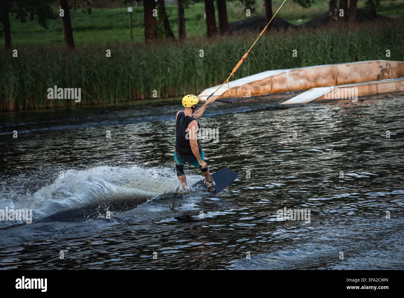 Wakeboarder schneidet hart über das Wasser. Stockfoto