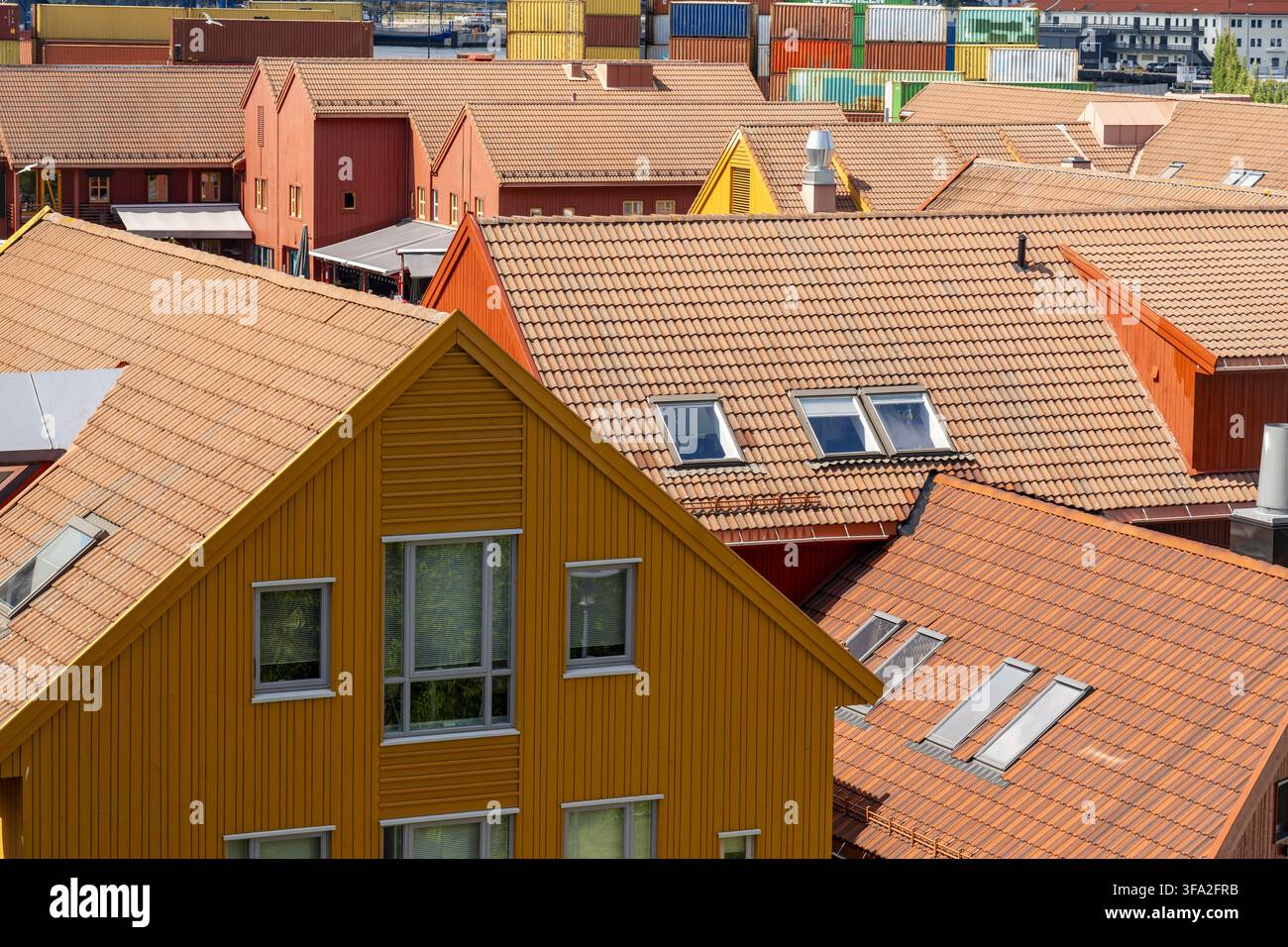 Blick auf farbenfrohe Holzhäuser mit Dachziegeln aus Terrakotta und Dachfenstern im historischen Viertel von Kristiansand, Agder, Norwegen. Stockfoto