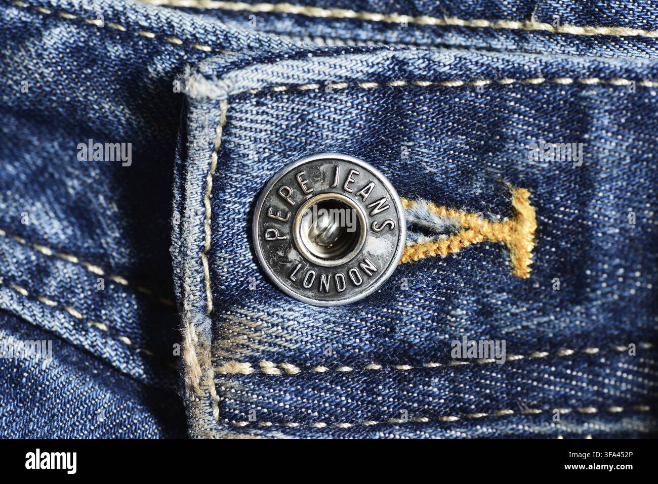 Pepe Jeans London Metallknopf an der Jeans, Nahaufnahme mit Branding und strukturiertem Material, Pepe Jeans Logo Stockfoto