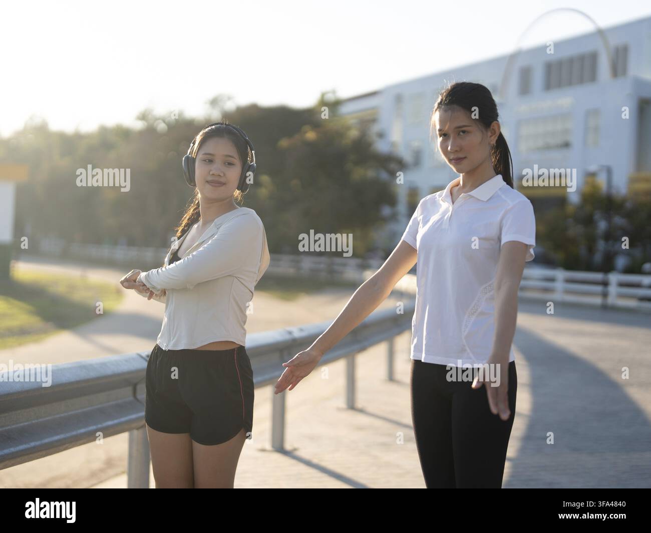 Zwei asiatische Frauen in Sportanzügen trainieren zusammen im Stadion Stockfoto