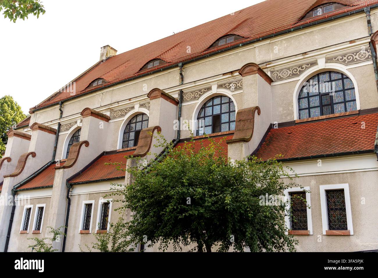 Eine Außenansicht eines historischen Steinbaus mit Terrazzoflieschendach und charakteristischen gewölbten Fenstern, das traditionelle europäische Architektur darstellt Stockfoto