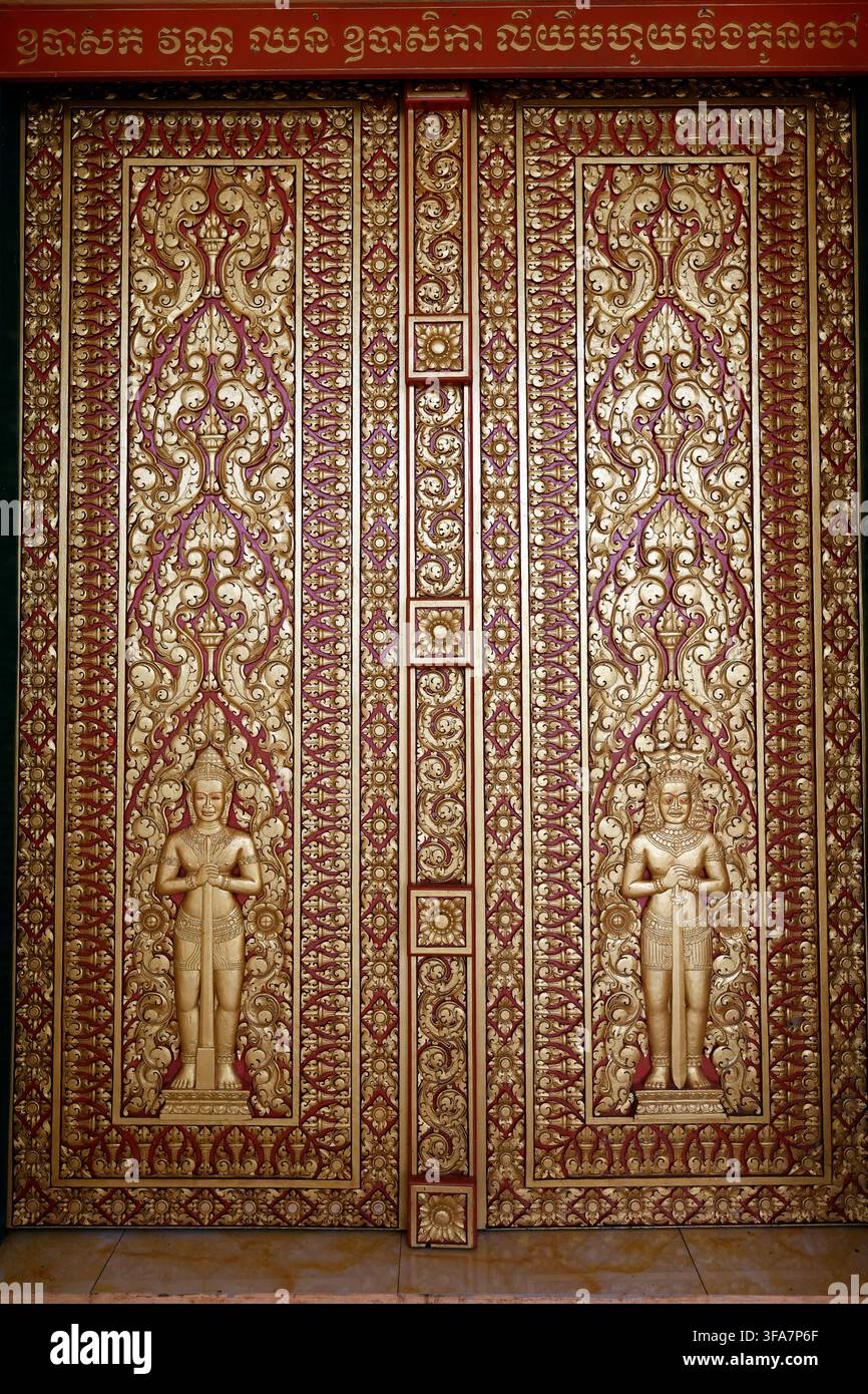 Verschnörkelte goldene Tempeltüren mit geschnitzten Wächterfiguren und aufwendigen Khmer-Blumenrankmustern. Siem Reap. Kambodscha. Stockfoto