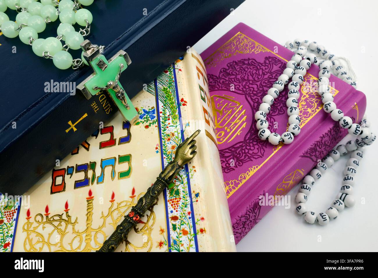 Eine Ansicht von oben auf jüdische, christliche und islamische heilige Bücher und Gebetsutensilien, die die Einheit der drei monotheistischen Religionen symbolisieren. Stockfoto
