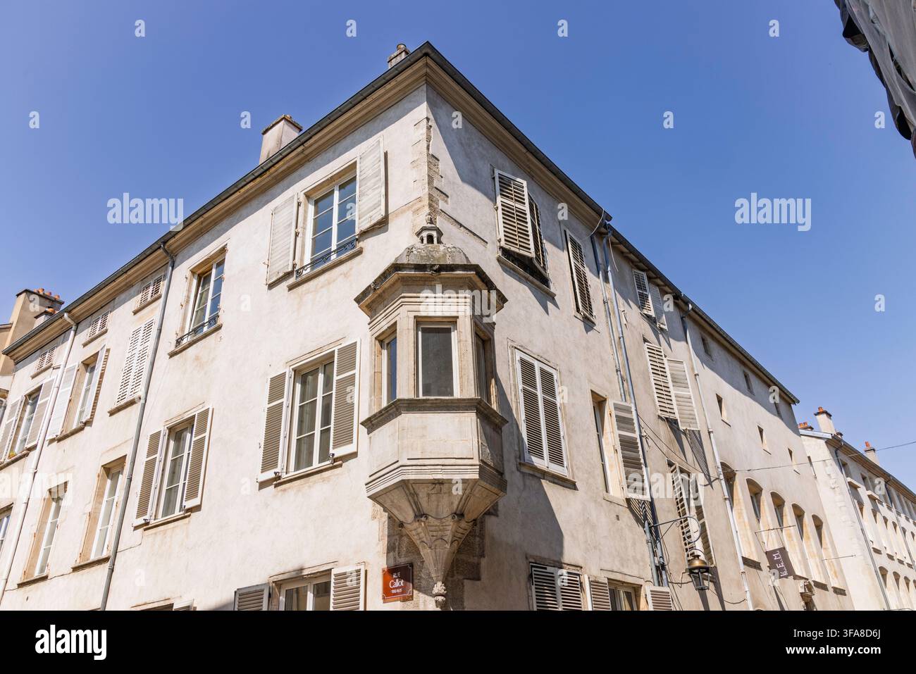 Nancy, Frankreich, 02. August 2026. Ecke eines alten Steingebäudes mit traditionellen hölzernen Fensterläden und einem eleganten Erkerfenster-Balkon Stockfoto