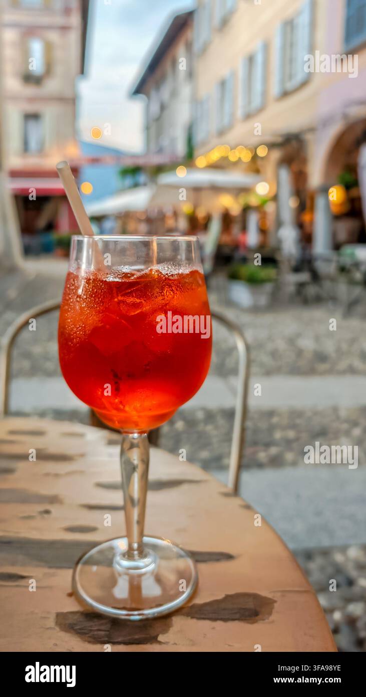 Traditionelles italienisches Aperitivo-Getränk, das auf einem Tisch serviert wird, mit einer bezaubernden historischen italienischen Stadt im Hintergrund, die authentische lokale Küche einfängt Stockfoto