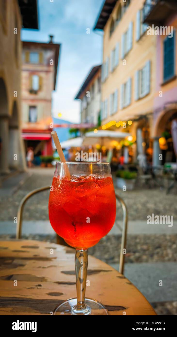 Traditionelles italienisches Aperitivo-Getränk, das auf einem Tisch serviert wird, mit einer bezaubernden historischen italienischen Stadt im Hintergrund, die authentische lokale Küche einfängt Stockfoto