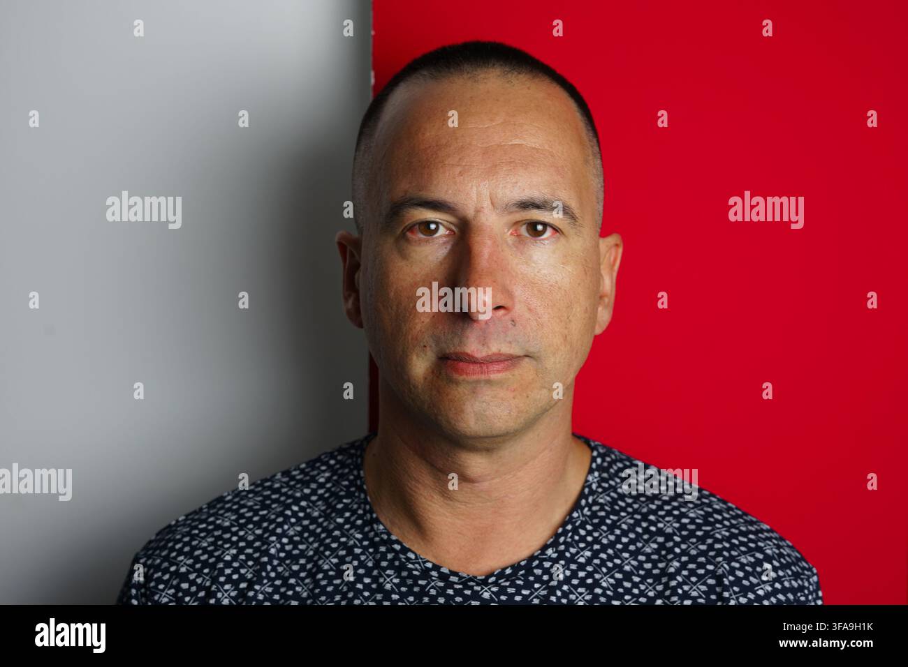 Gesicht eines 37-jährigen Marokkaners vor einem weiß-roten Wandhintergrund. Stockfoto