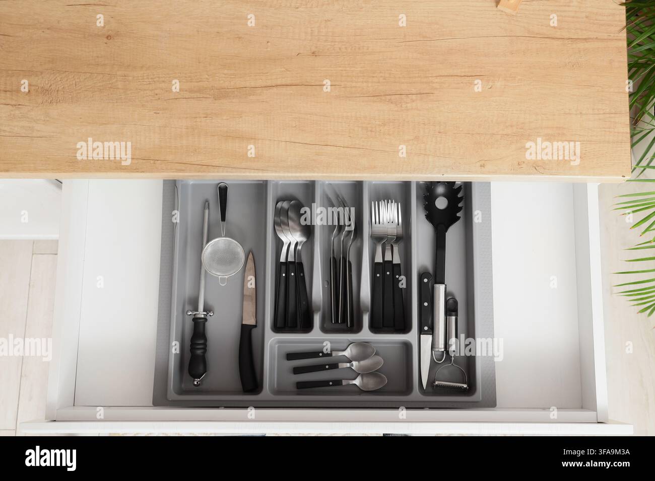 Küchenorganisation und Heimkochen, Blick von oben auf eine offene Schublade mit ordentlich angeordnetem Besteck und Utensilien Stockfoto
