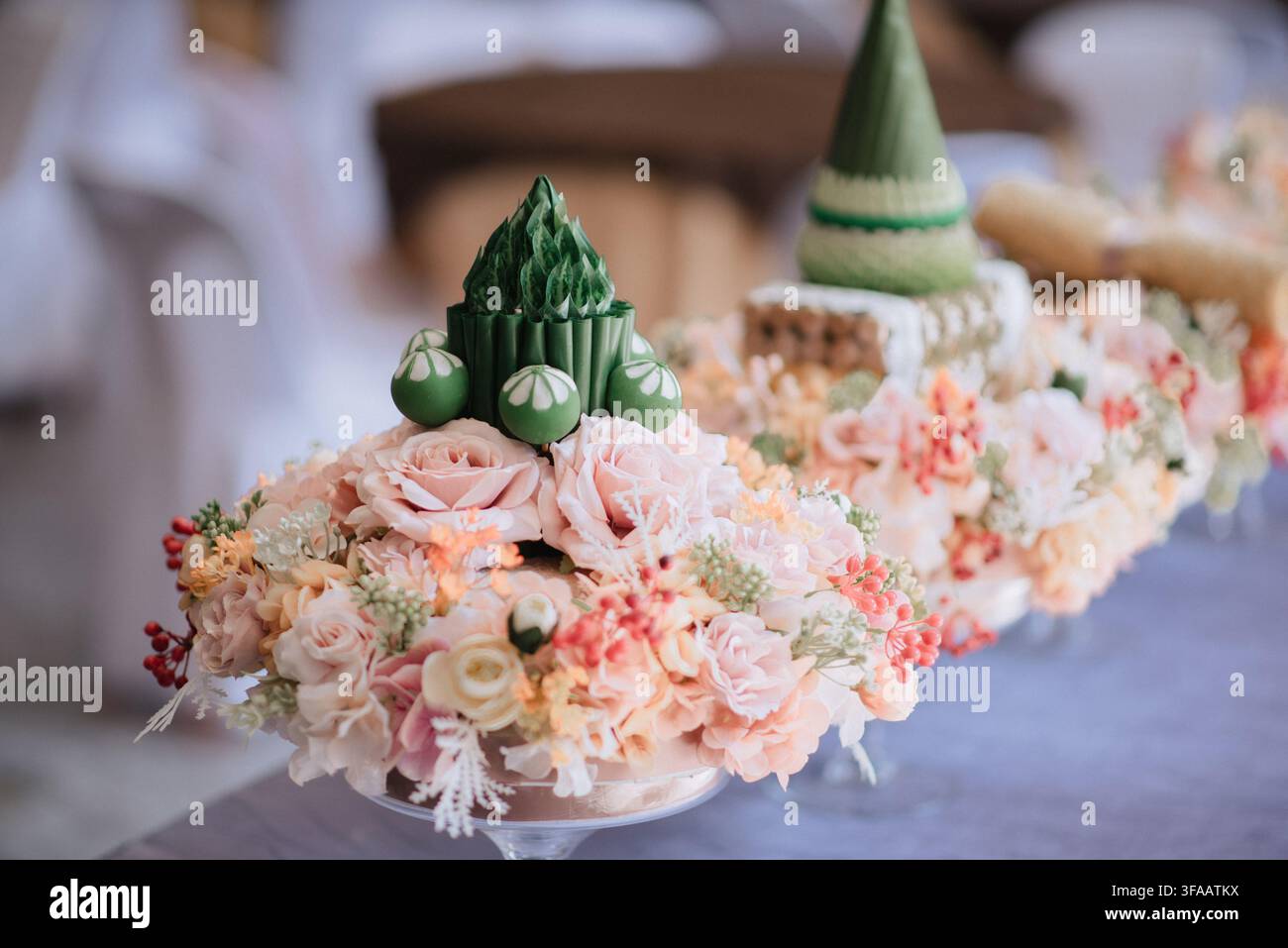 Traditionelles Banketttisch-Mittelstück aus gefalteten Blättern und Blumen. Stockfoto
