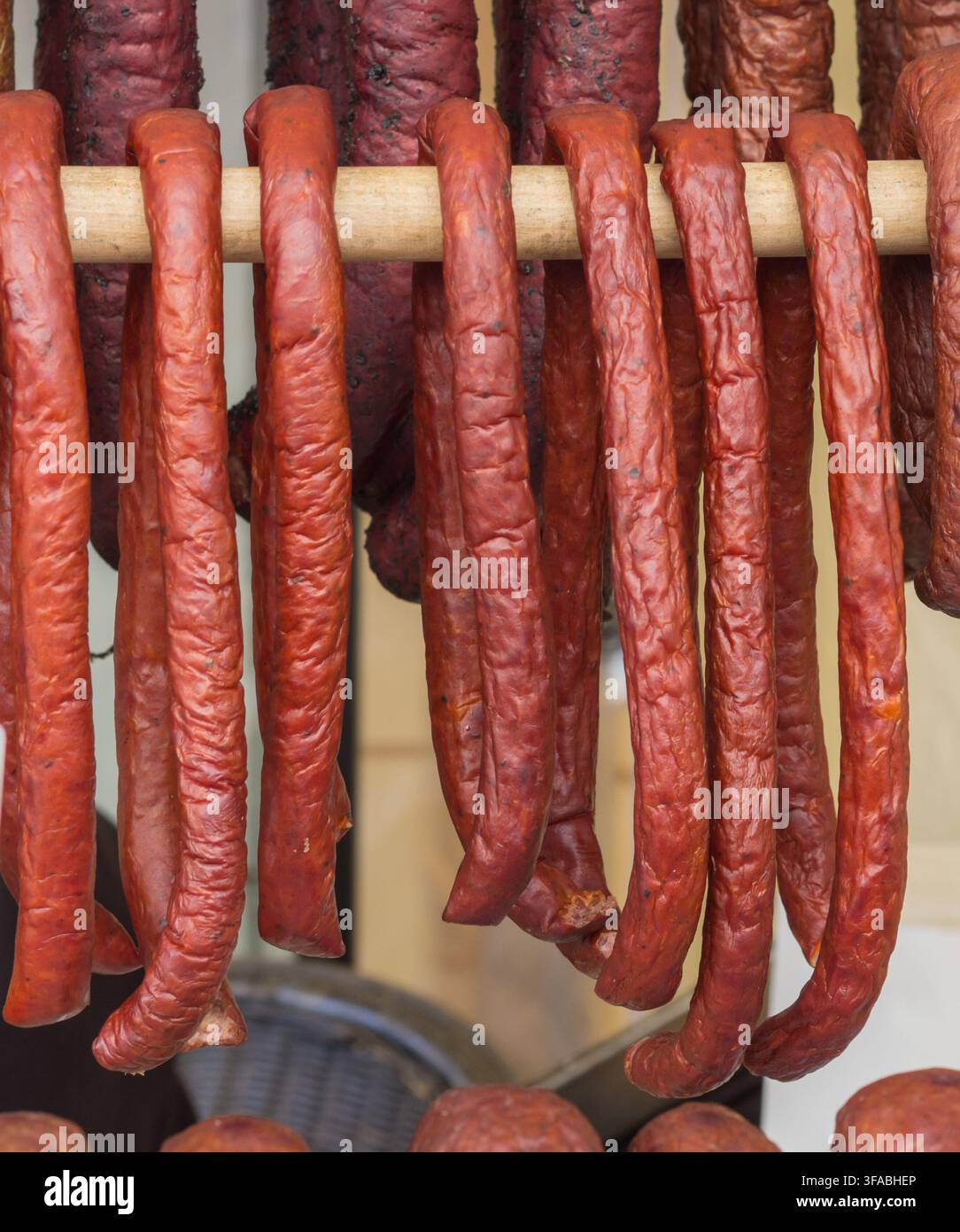 Traditionelle polnische geräucherte Würste an einer Holzstange hängend. Stockfoto