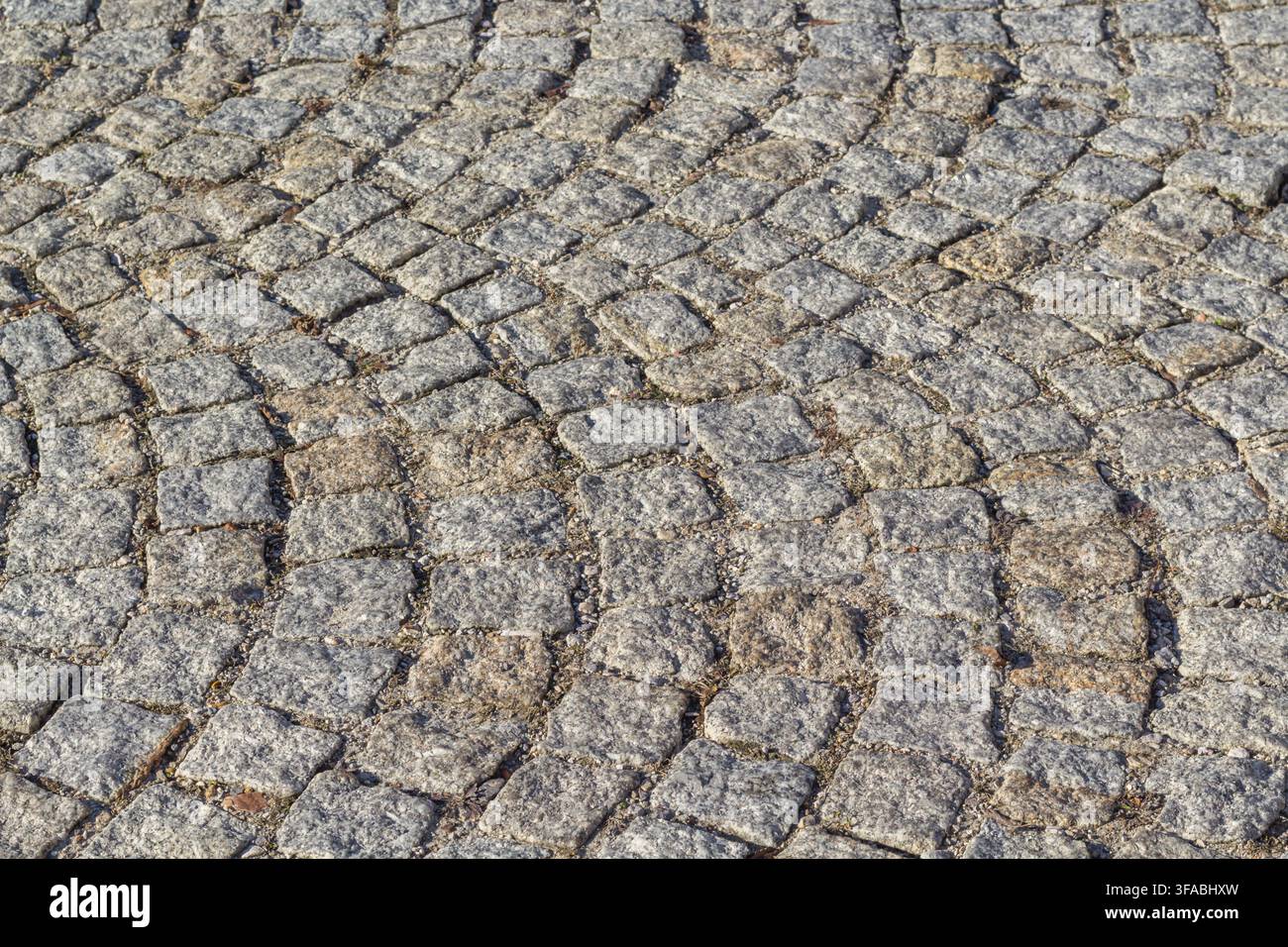 Kopfsteinpflaster mit einer strukturierten Steinoberfläche. Stockfoto