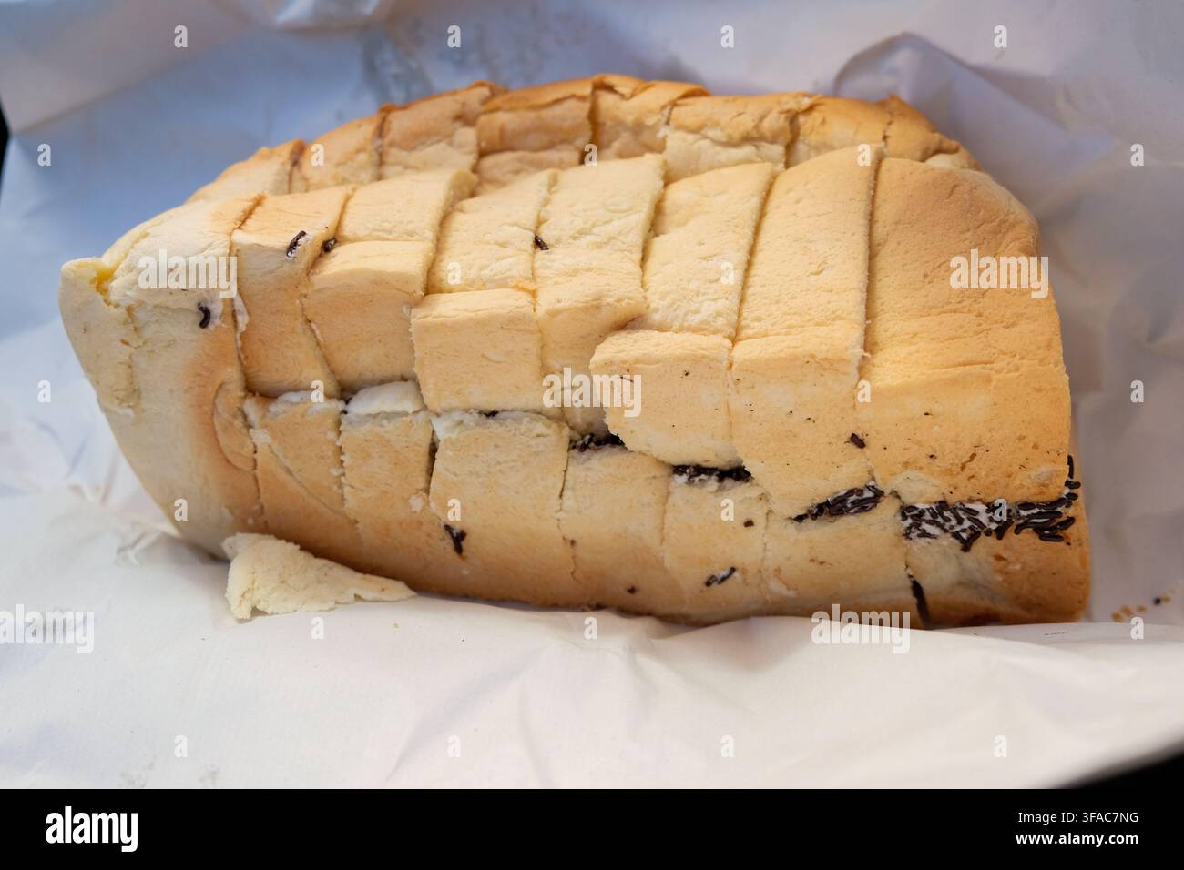 Pematang Siantar, Indonesien – 2. Mai 2025: Roti ganda, geschnittenes Brotlaib mit Sahne und Schokoladenstreuseln Stockfoto