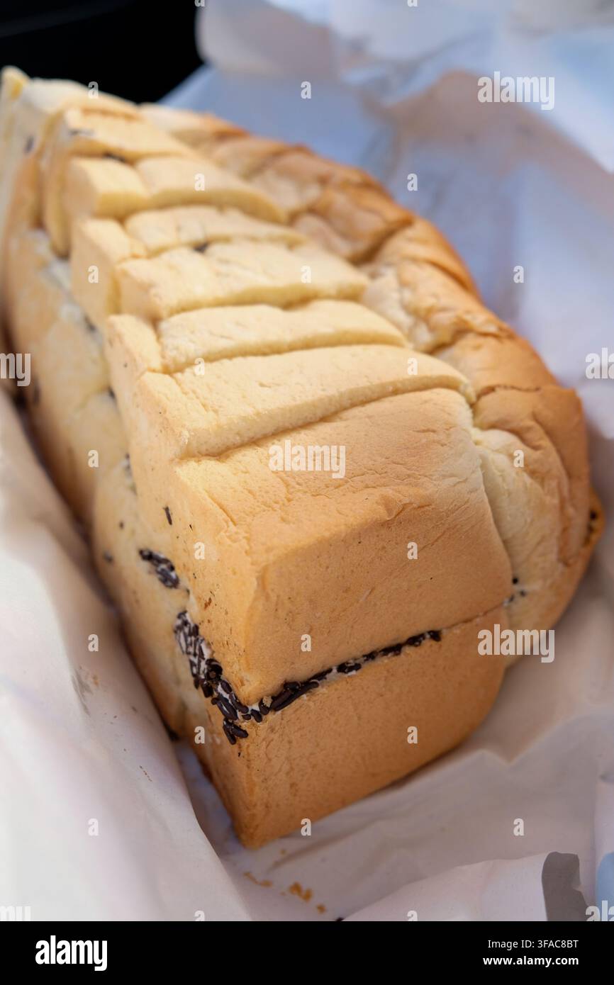 Pematang Siantar, Indonesien – 2. Mai 2025: Roti ganda, geschnittenes Brotlaib mit Sahne und Schokoladenstreuseln Stockfoto