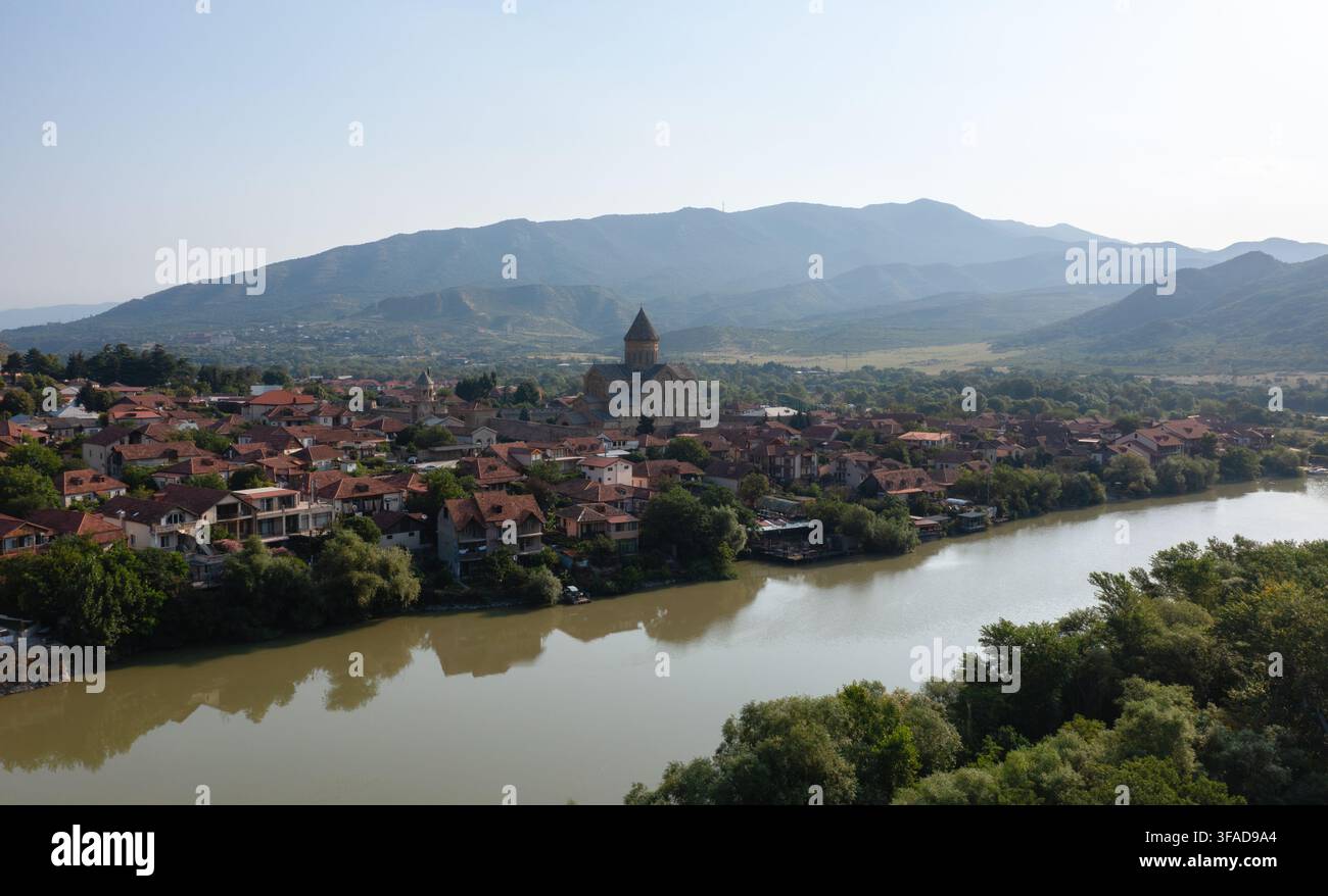 Panoramablick auf das historische Mtskheta mit der Svetitskhoveli-Kathedrale, dem Mtkvari-Fluss und dem Kaukasusgebirge. Stockfoto