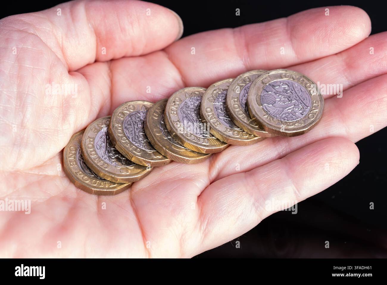Münzen ruhen auf der Handfläche bei gutem Licht Stockfoto
