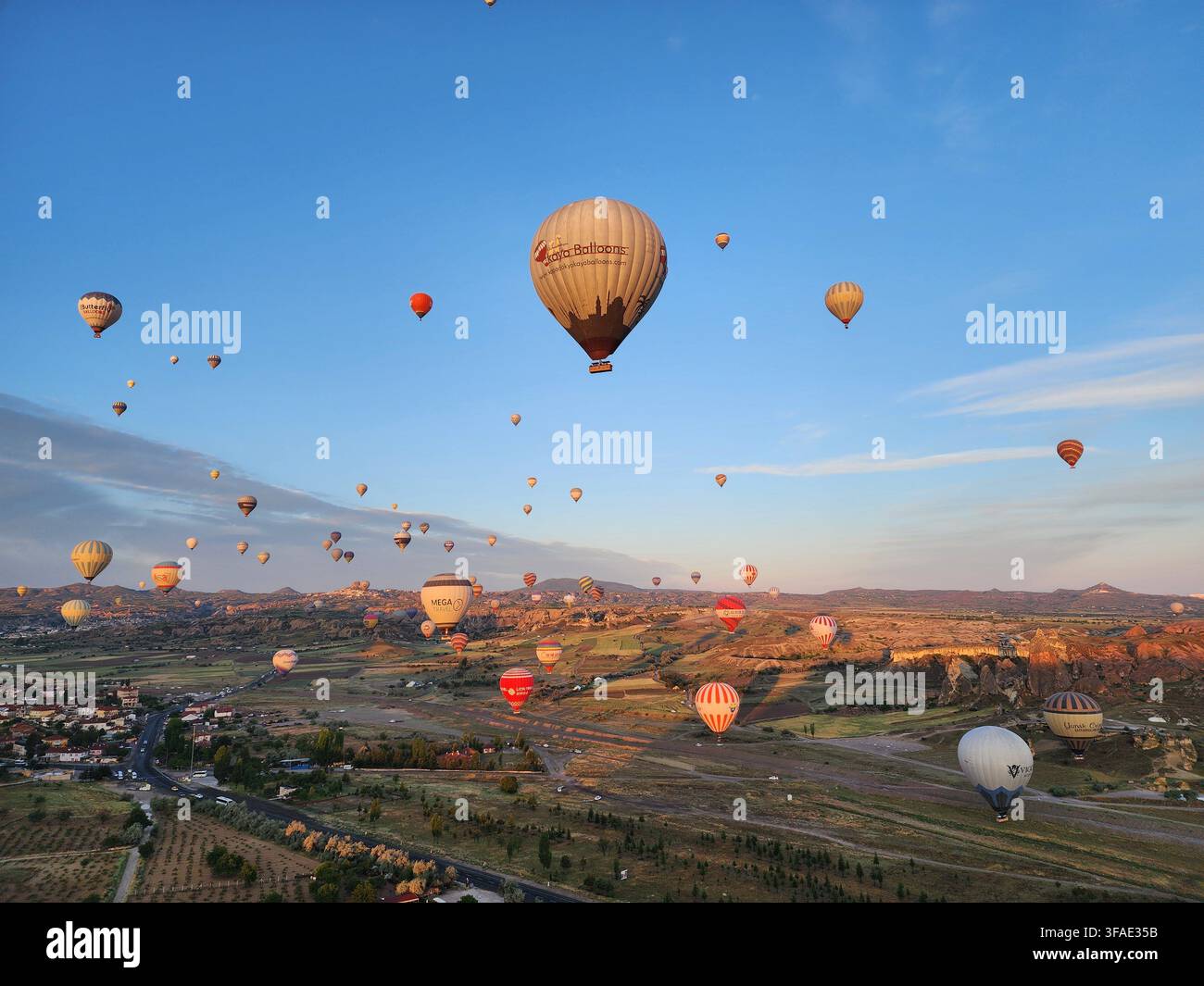 Heißluftballone fliegen über die Landschaft der Kappadokien bei Sonnenaufgang, Göreme, Türkei. - Smartphone-aufgenommenes Stockfoto
