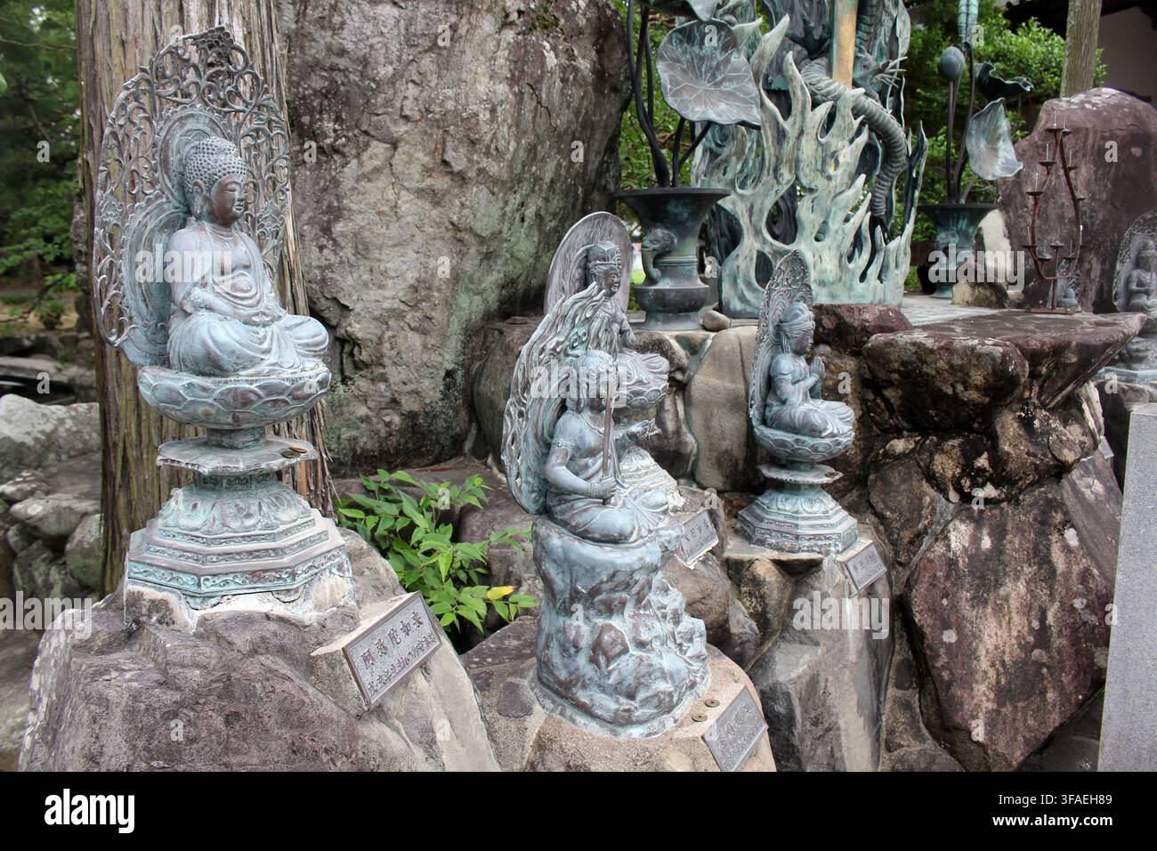 kleine bronzene buddhistische Statuen auf felsigen Podesten im Konsenji-Tempel, drittem Tempel der Shikoku-Henro-Pilgerreise in Itano, Tokushima, Japan Juli 2026. Stockfoto