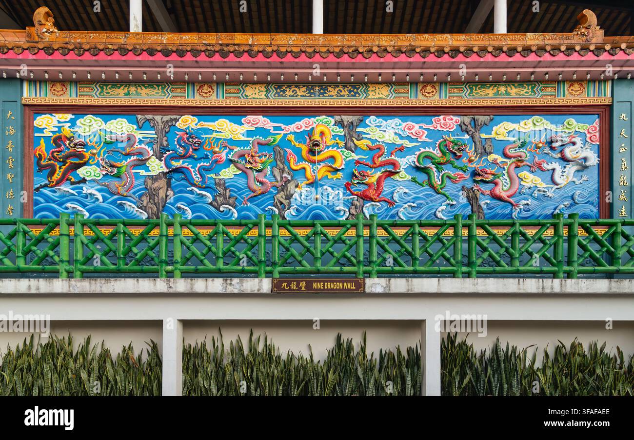 Farbenfrohe Nine Dragon Wall-Malererei mit kunstvollen chinesischen Drachen im Chin Swee Caves Temple in Genting Highlands, Malaysia, vor einem lebendigen blauen Hintergrund Stockfoto