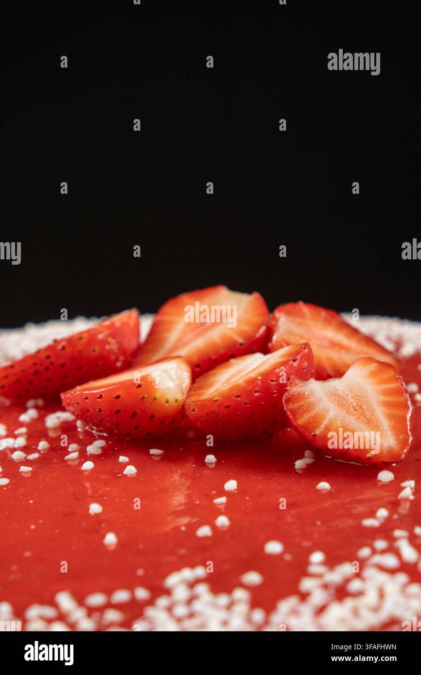 Köstlicher Erdbeer-Gelee-Kuchen, der mit geschnittenen reifen Beeren gekrönt ist. Stockfoto