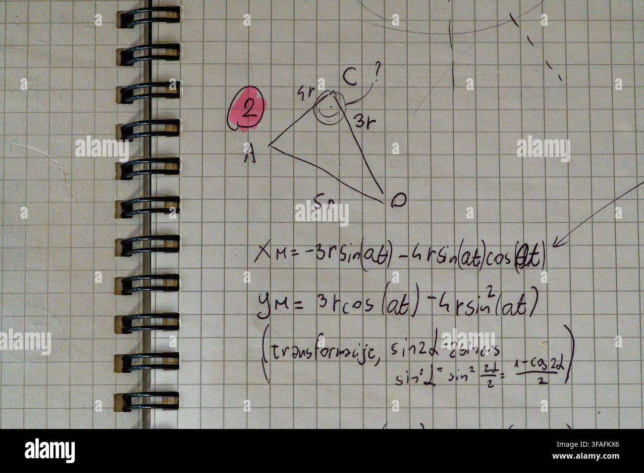 Eine Notizbuchseite mit Spiralbindung zeigt ein von Hand gezeichnetes Dreiecksgeometrieproblem und trigonometrische Umformlungsformeln in schwarzem Stift. Stockfoto