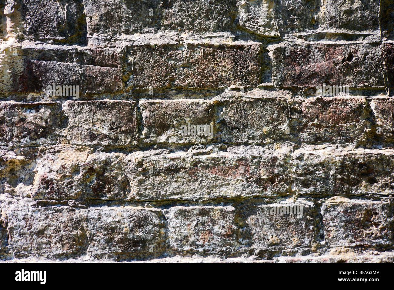 Ein altes Mauerwerk einer Brücke, das seine raue Textur im vollen Sonnenlicht freilegt. Stockfoto