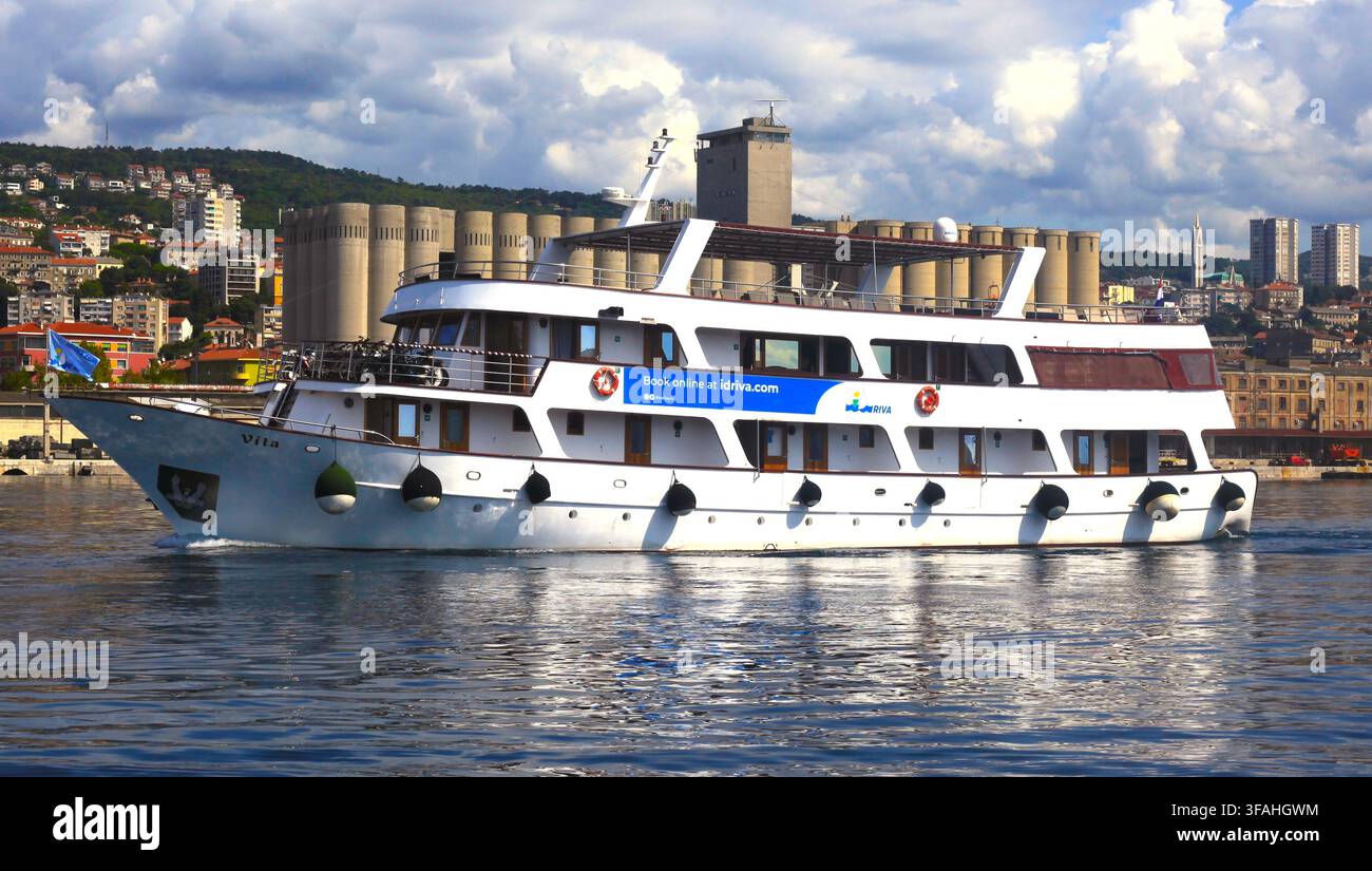 Passagier-Kreuzfahrtschiff Vita segelt in blauen Gewässern des Hafens vor der Stadt Skyline und den Hügeln in Rijeka, Kvarner-Bucht, Kroatien. Stockfoto