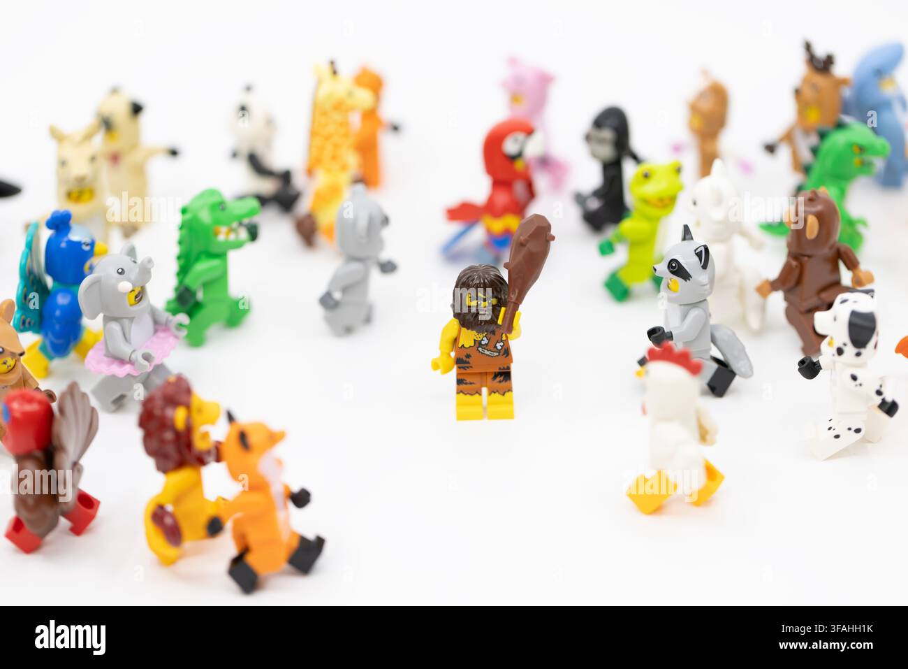 Hong Kong, 8. Juni 2026: Ein Höhlenmensch, der einen Knüppel hält, steht selbstbewusst inmitten einer großen Gruppe von Minifiguren in verschiedenen Tierkostümen. Stockfoto
