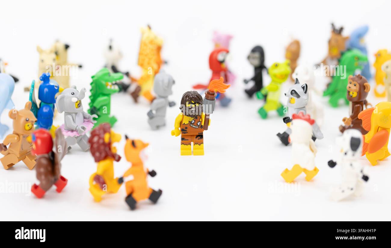Hong Kong, 8. Juni 2026: Ein Höhlenmensch, der einen Knüppel hält, steht selbstbewusst inmitten einer großen Gruppe von Minifiguren in verschiedenen Tierkostümen. Stockfoto