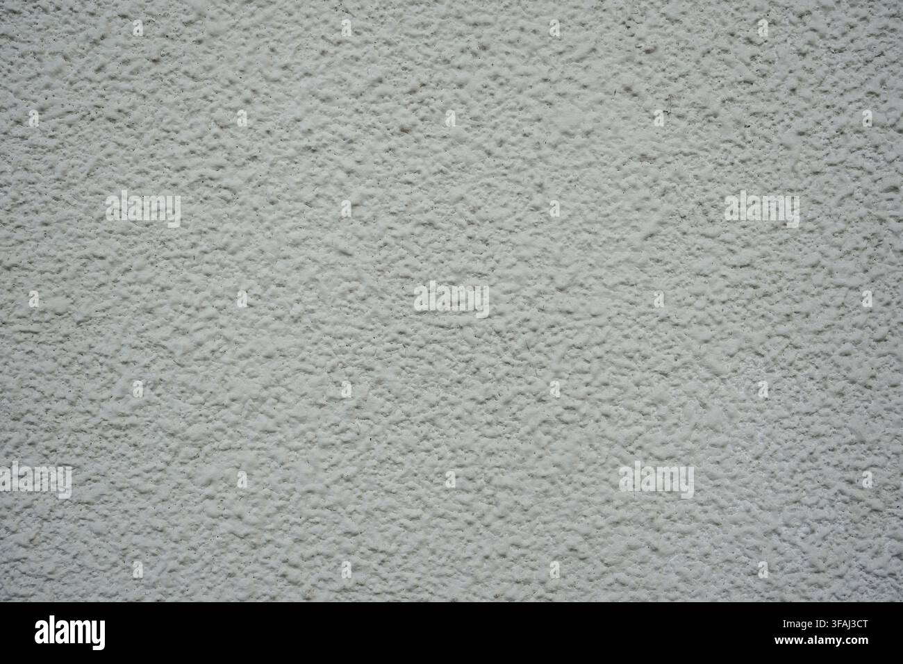 Nahaufnahme einer weißen Außenwand mit einer schweren, holprigen Schlickputzoberfläche. Eine saubere, gleichmäßige architektonische Textur, ideal für leere Hintergründe. Stockfoto