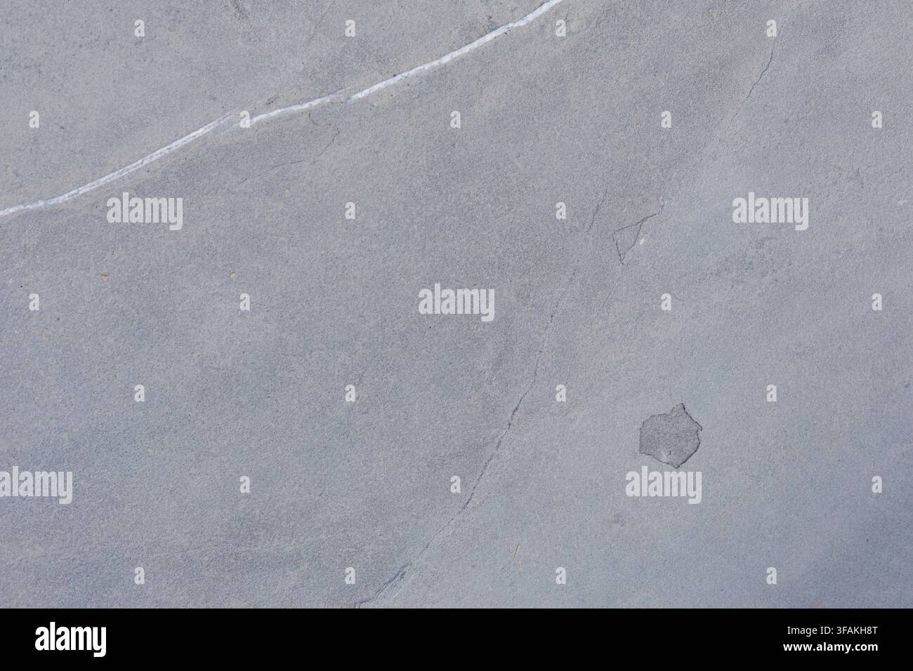 Blaugraue Schiefersteinoberfläche mit weicher natürlicher Maserung und glatter mineralischer Textur, ideal für moderne Architektur und elegante Hintergründe Stockfoto