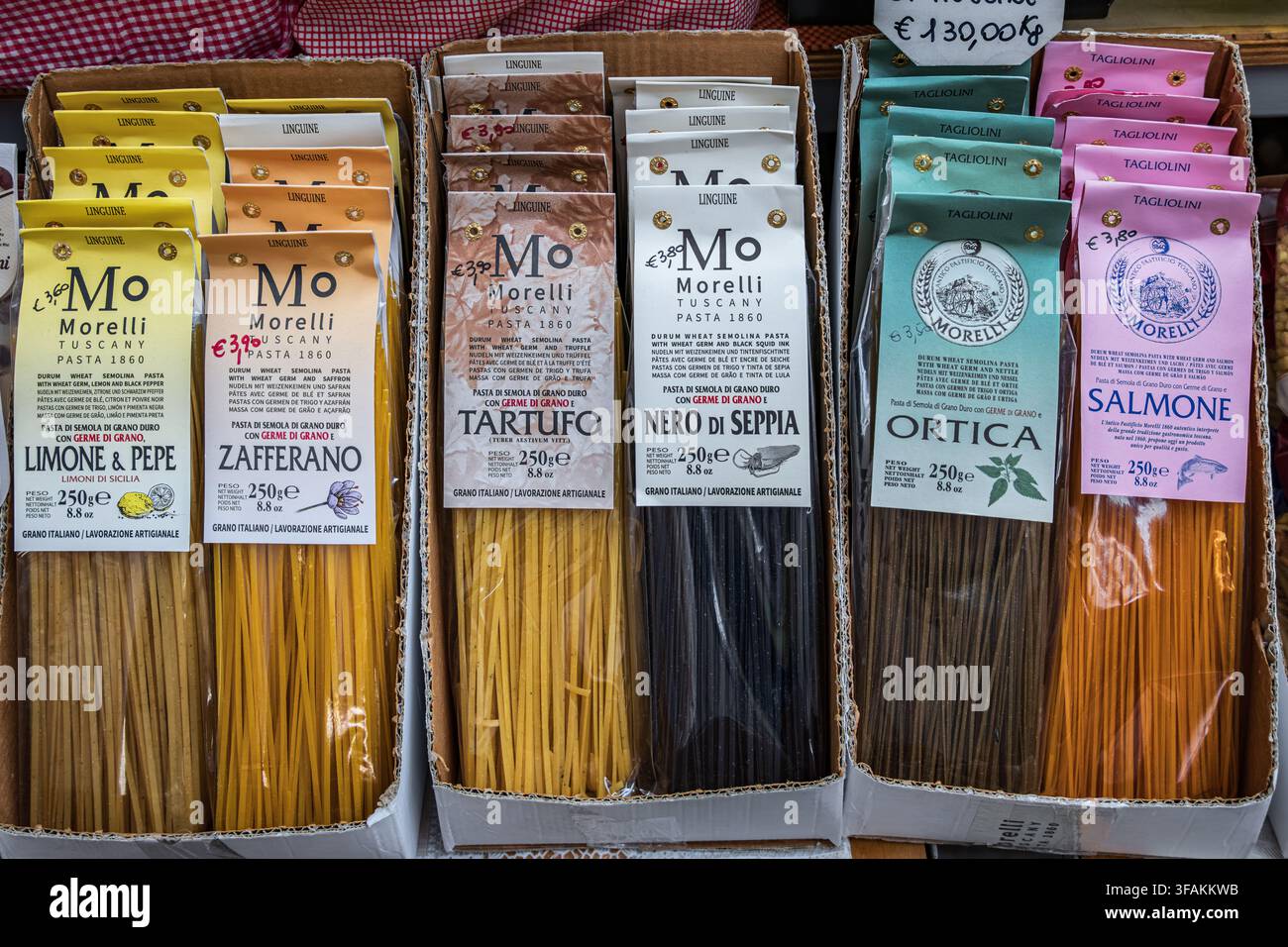 Sanremo, Italien - 30. Mai 2024: Bunte handwerklich hergestellte Linguine-Pasta mit Spinat, Trüffel, Safran, Nessel, Lachs und Tintenfisch-Tinte auf einem Bauernmarkt Stockfoto