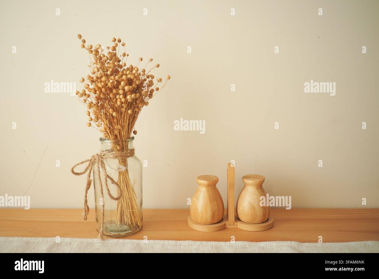 Eine Glasvase hält getrocknete Blumen Stockfoto