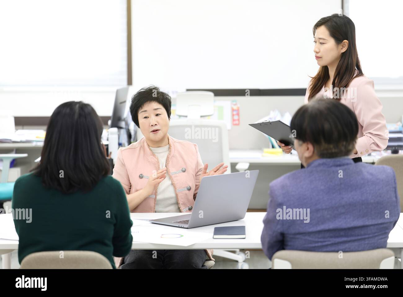 Senior-Koreanische-Frauenmanagerin leitet eine Teambesprechung in einem modernen Büro Stockfoto
