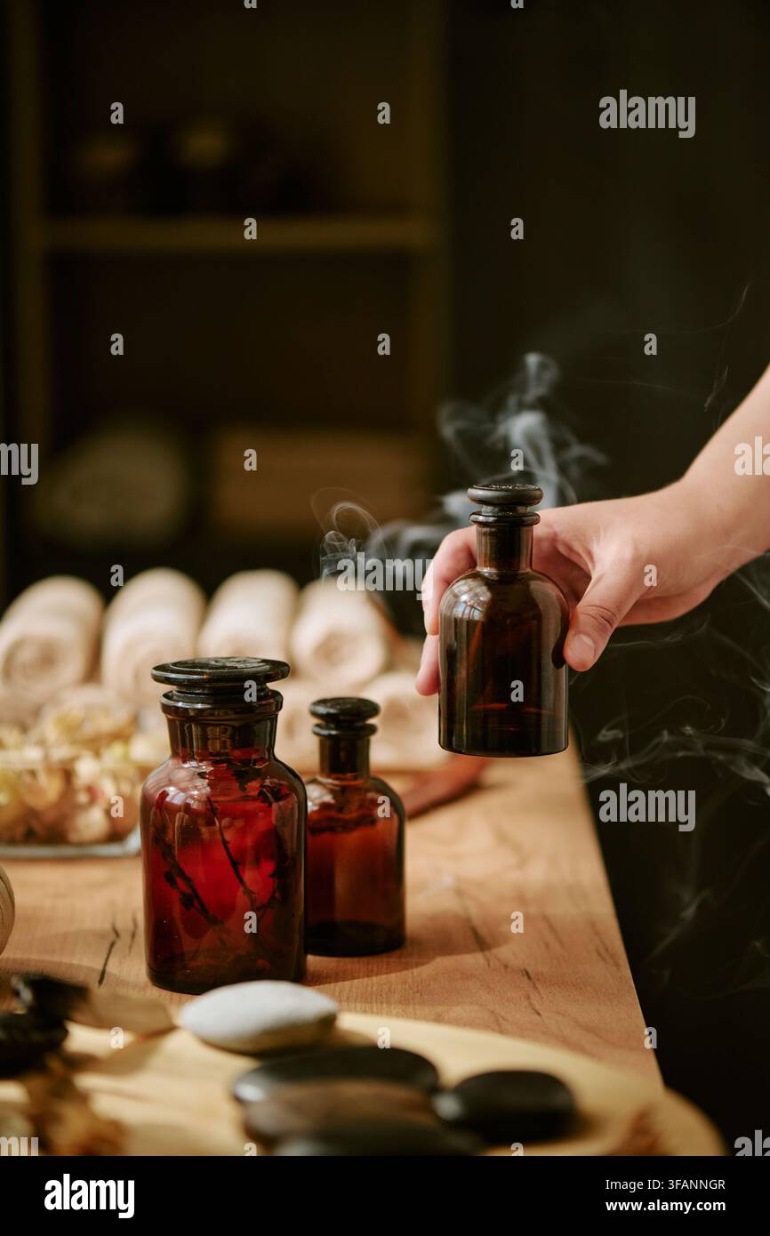 Frau hält eine Flasche mit ätherischem Öl in einem Wellness-Spa-Salon Stockfoto