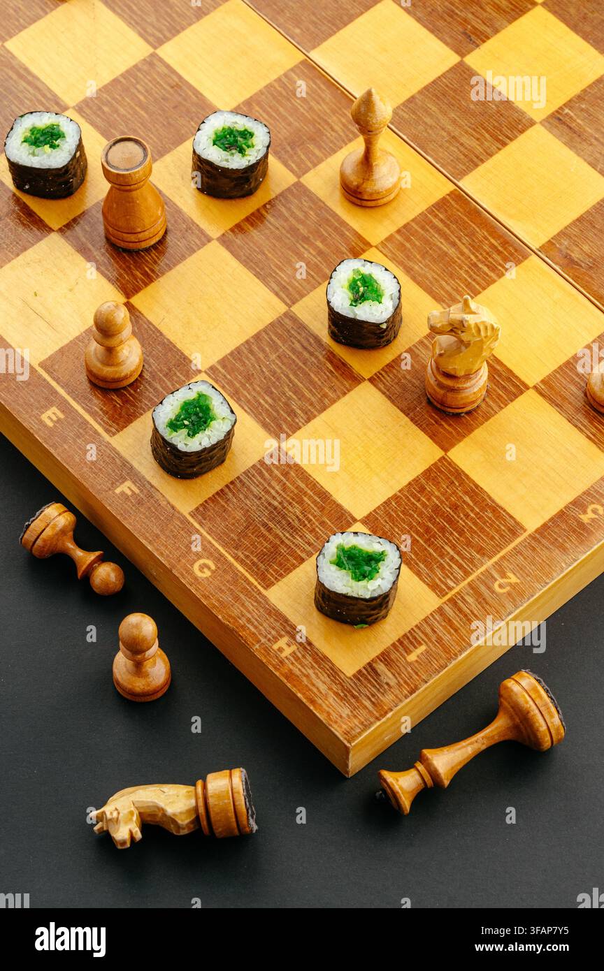 Sushi-Maki-Rollen, die als Figuren auf einem Schachbrett verwendet werden Stockfoto