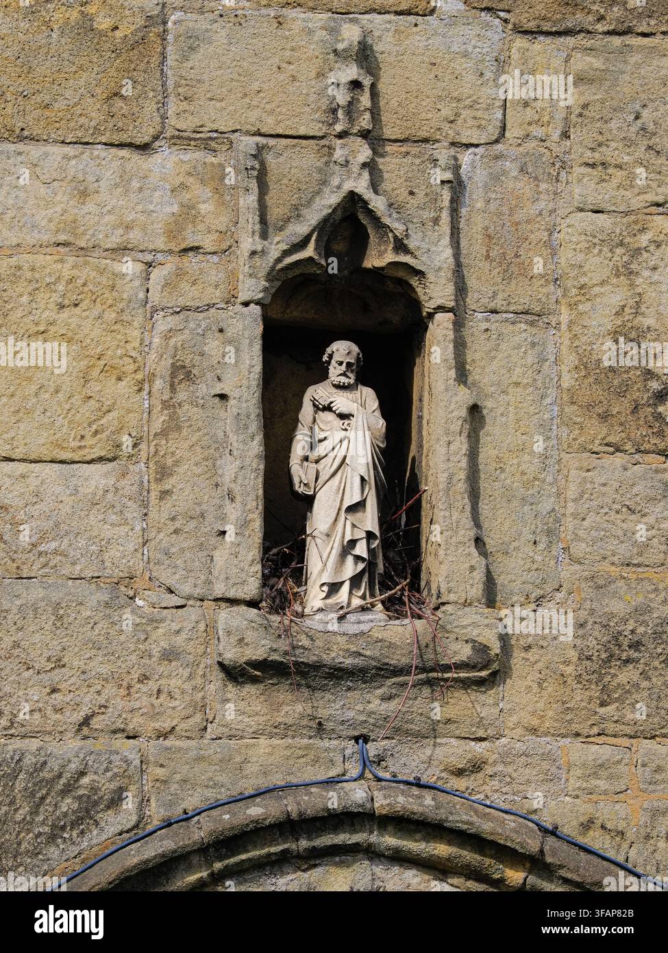 Verwitterte Steinstatue des heiligen Petrus in einer Nische Stockfoto