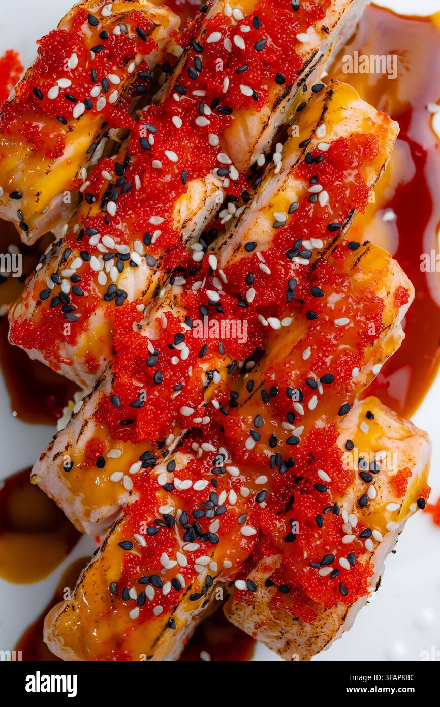 Gegrillte Lachs-Sushi-Rollen mit Tobiko und Samen Stockfoto