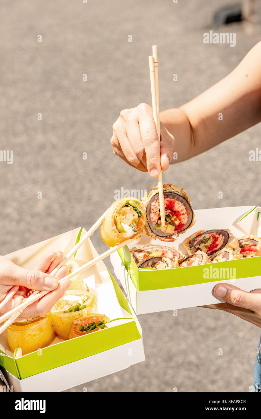 Freunde teilen verschiedene Arten von Sushi-Rollen Stockfoto