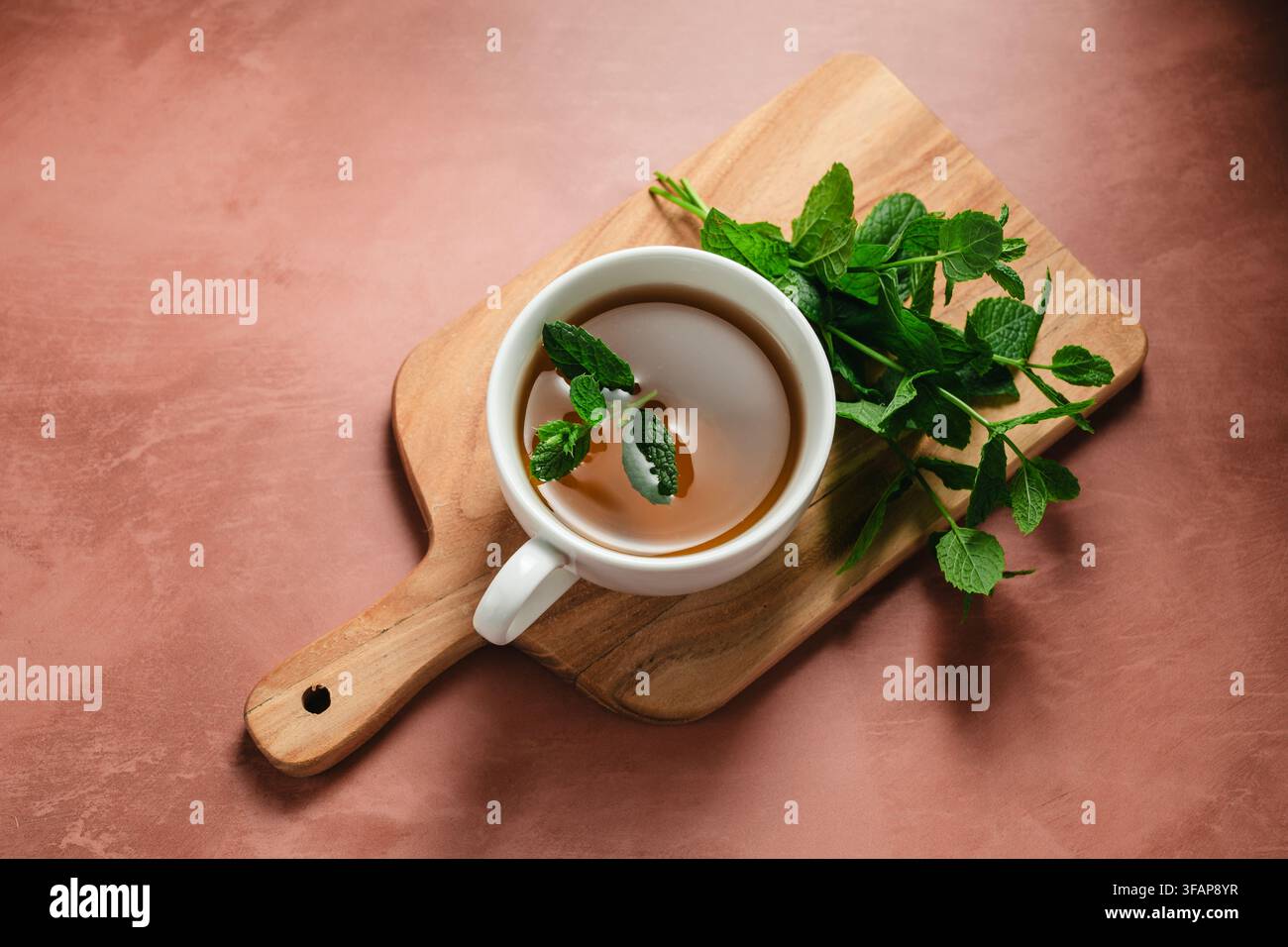 Frisch gebrühter Minztee auf einem Holzservierteller Stockfoto