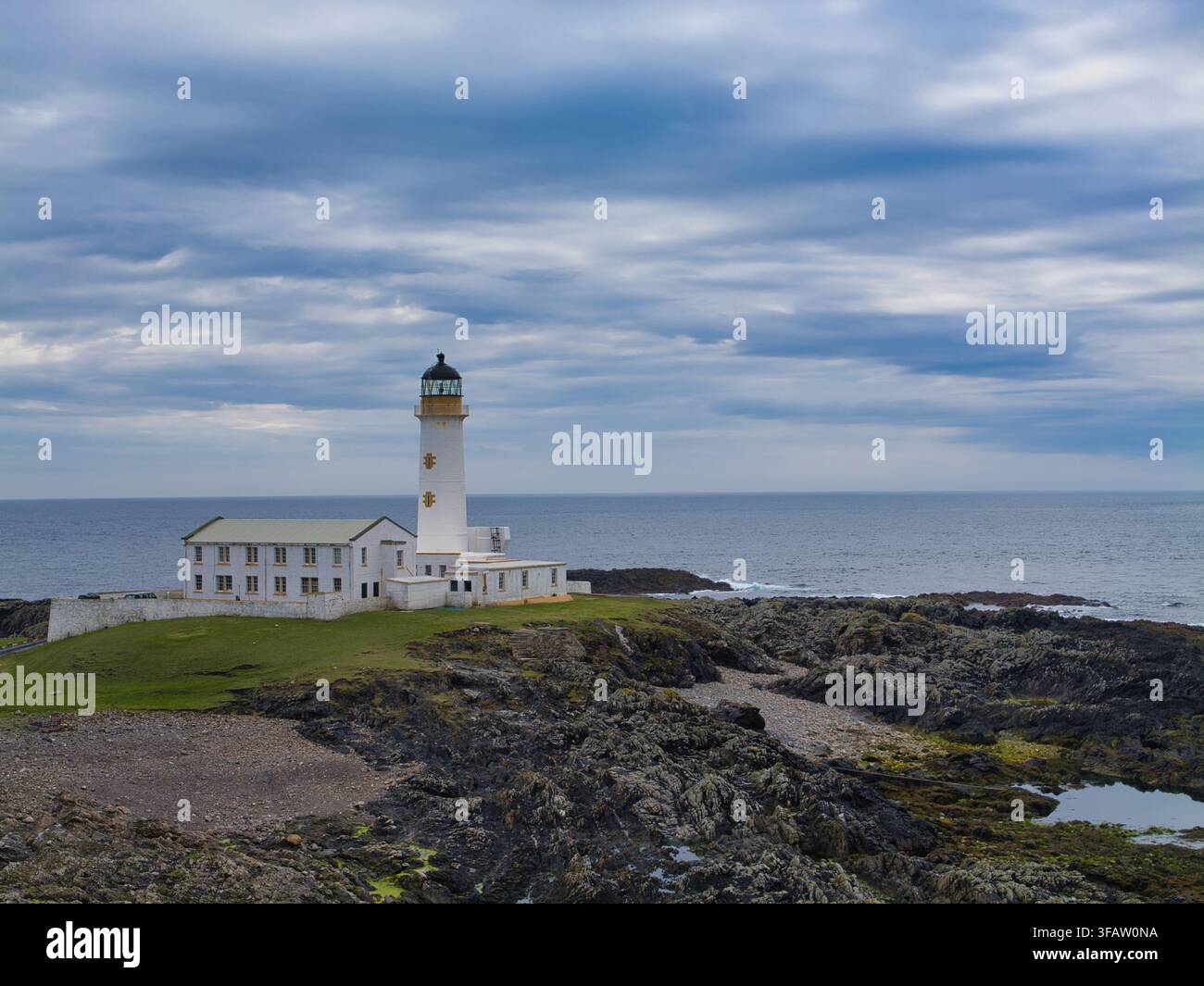 Fair Isle, UK – 22. Mai 2026: Der Südlighthouse auf Fair Isle UK erhebt sich über dunkle felsige Küsten und das offene Meer unter einem dramatischen, wolkenverhangenen Himmel Stockfoto