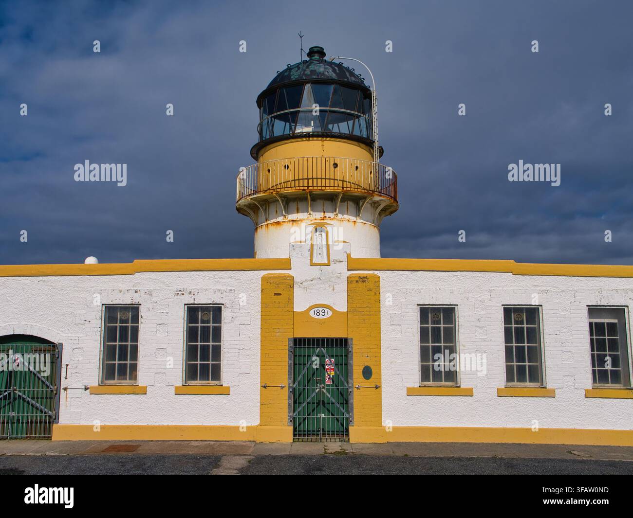 Fair Isle, UK - 23. Mai 2026: Historischer Nord-Leuchtturm auf Fair Isle UK mit weißer und gelber Fassade unter düsteren Küstenwolken Stockfoto
