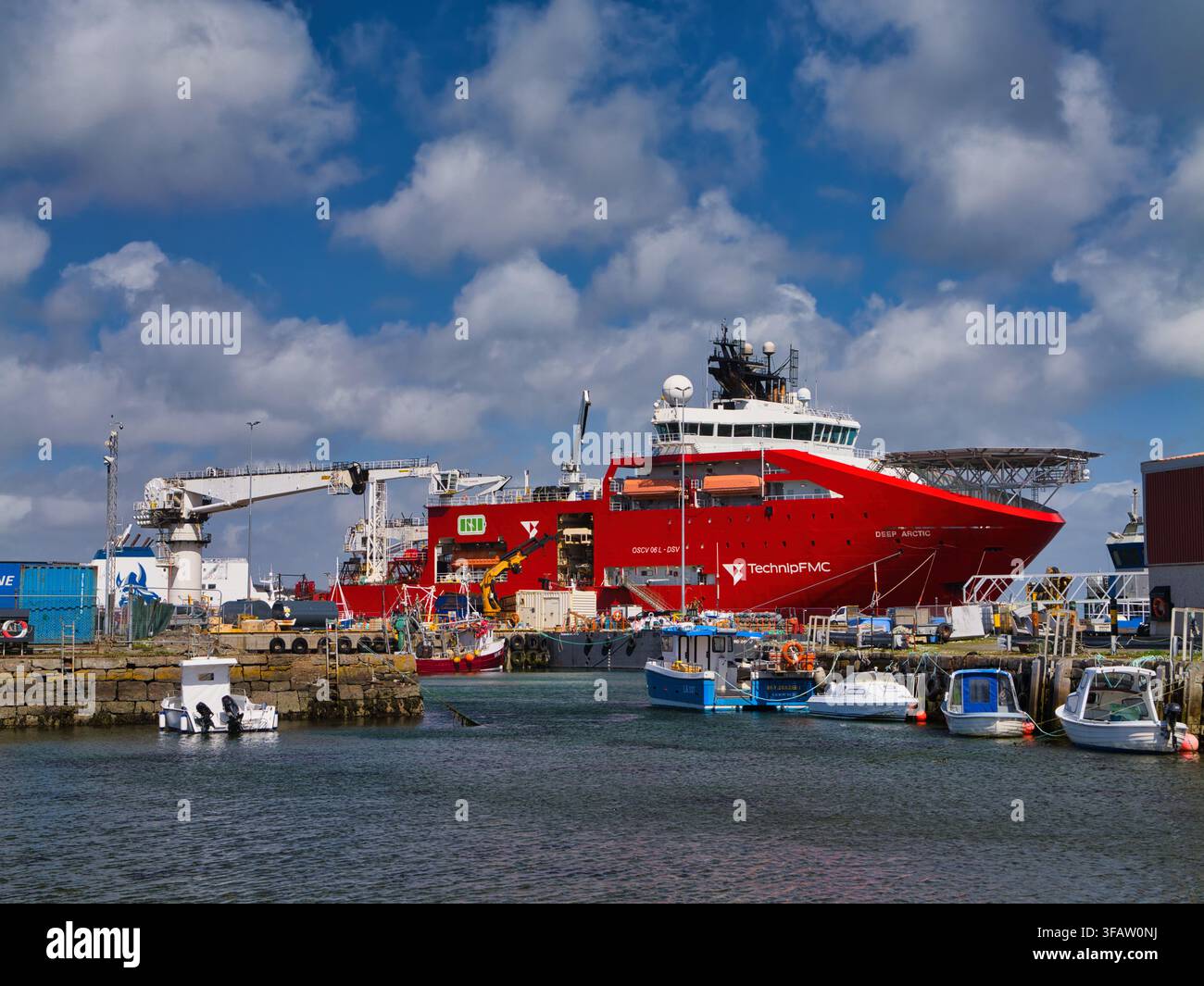 Shetland, UK - 26. Mai 2026: Tiefes arktisches Tauchunterstützungsschiff, das in einem Arbeitshafen in Shetland UK unter dramatischen Wolken und blauem Himmel vertäut ist Stockfoto